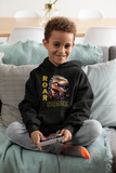Young boy smiling while wearing a black ROARSOME kids dinosaur hoodie for boys and girls.